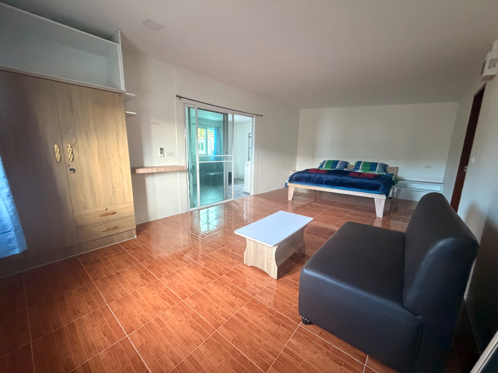 Innenansicht eines Bungalows mit Bett und Sitzbereich